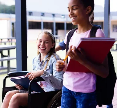 Mädchen im Rollstuhl mit ihrer Mitschülerin 