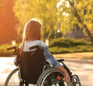 Jugendliche von hinten im Rollstuhl sitzend